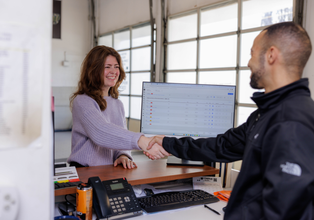 Service employee shaking hands with a customer over a desk