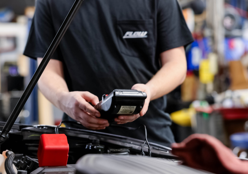 Service tech running diagnostics under the hood of a car